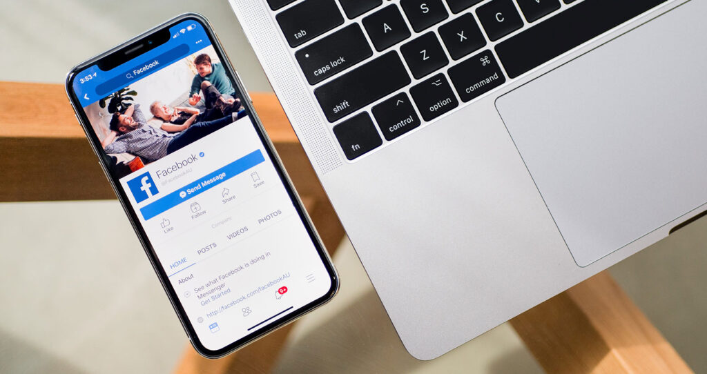 Smartphone with Facebook open beside a laptop, representing digital marketing in Dublin.