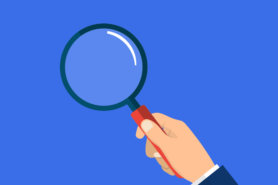 Hand holding magnifying glass on blue background, representing digital marketing focus, Dublin agency expertise.